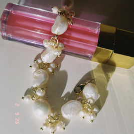 Pearl bracelet with gold accents on a pink lip gloss