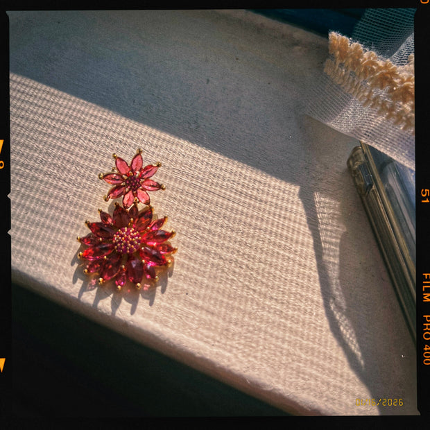 Someday she - The Pomegranate Stain vintage ruby red crystal floral earrings, showcasing intricate gold details and sparkling red gemstones in dramatic natural sunlight.