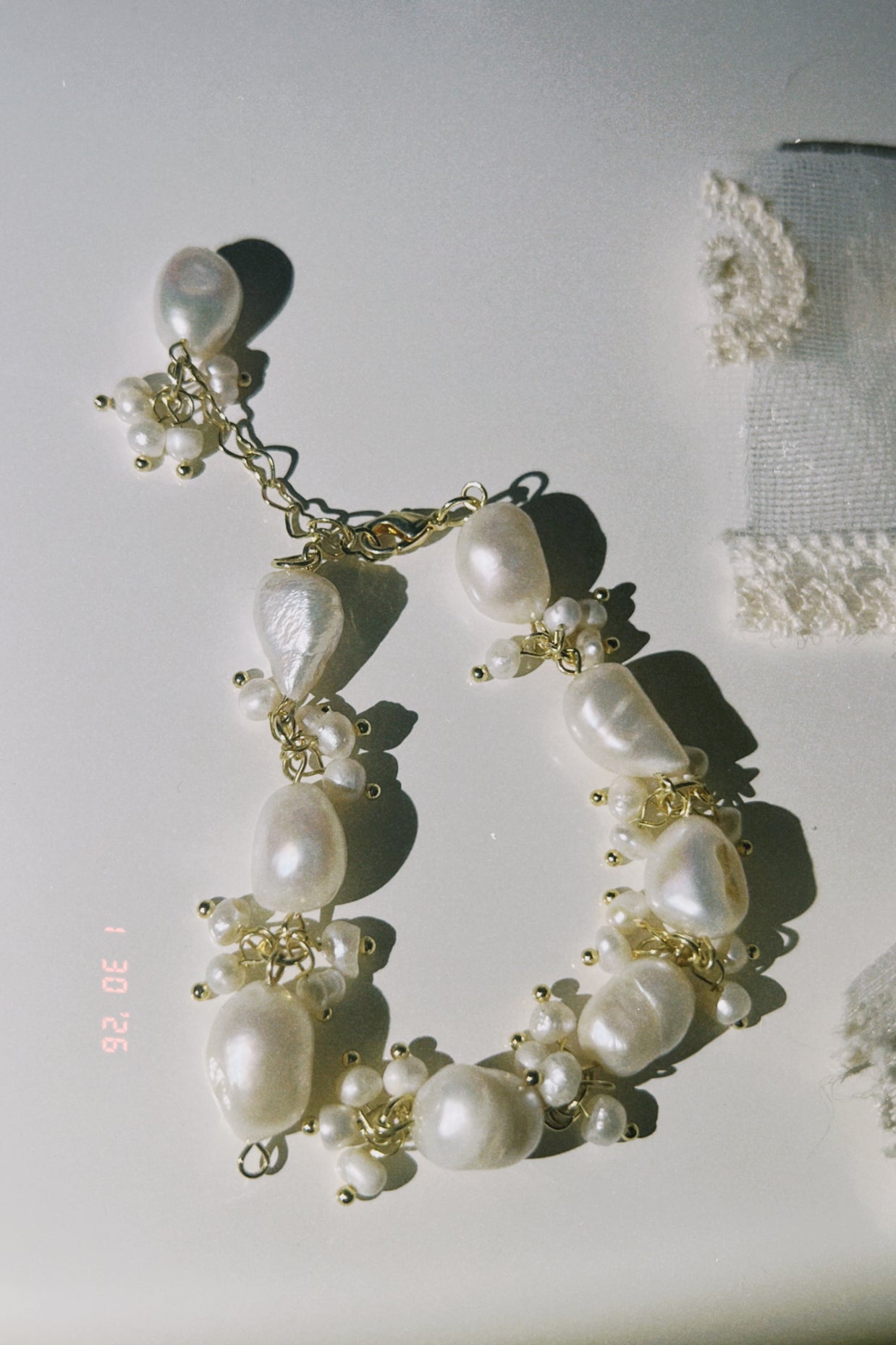 Someday she - The Unfinished Poem handcrafted baroque pearl cluster bracelet with gold-toned accents, featuring irregular organic pearls in a soft, sun-drenched setting.