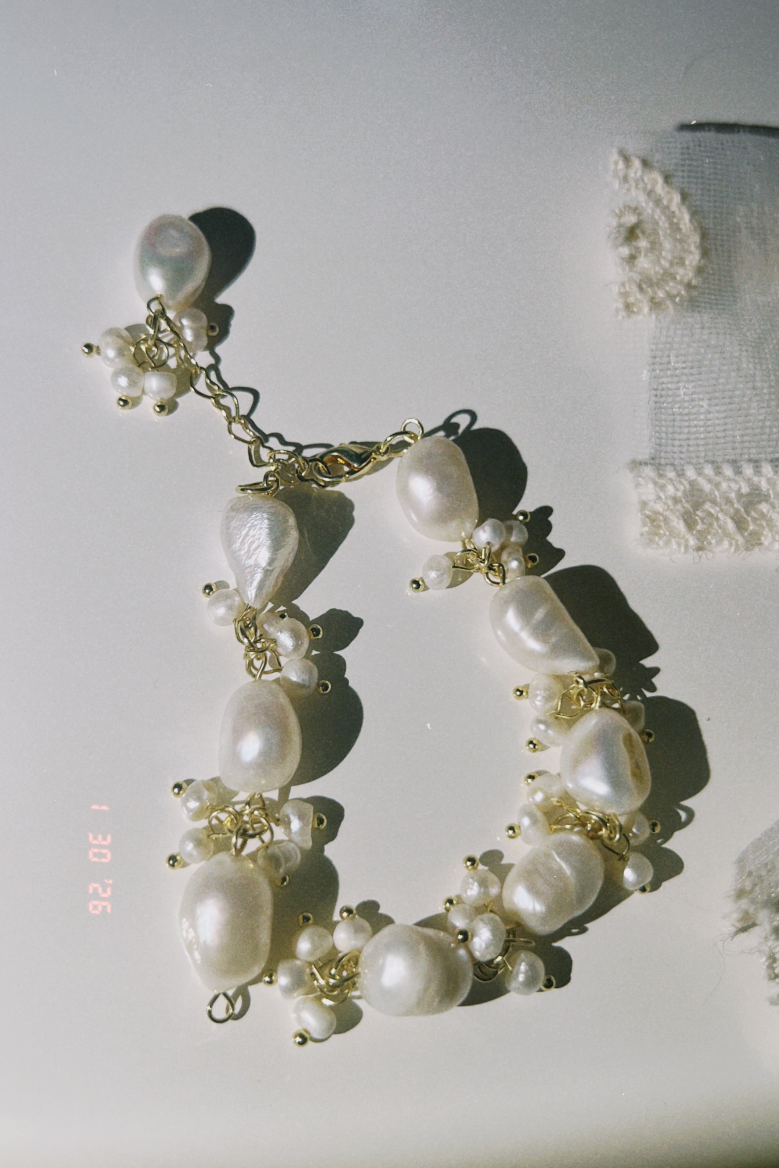 Someday she - The Unfinished Poem handcrafted baroque pearl cluster bracelet with gold-toned accents, featuring irregular organic pearls in a soft, sun-drenched setting.