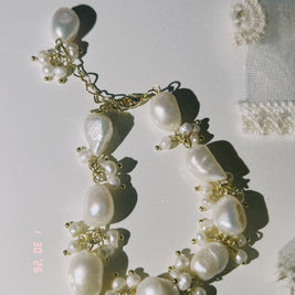 Someday she - The Unfinished Poem handcrafted baroque pearl cluster bracelet with gold-toned accents, featuring irregular organic pearls in a soft, sun-drenched setting.